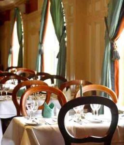 un gruppo di tavoli con sedie e bicchieri da vino di River Island Hotel a Castleisland