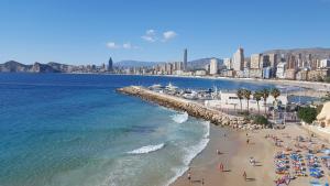 una spiaggia con una folla di persone e l'oceano di Apartament Solar ad Alicante