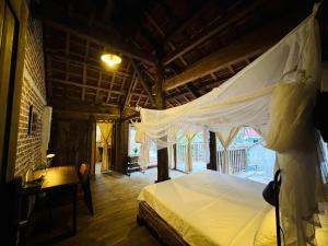 a bedroom with a bed with a mosquito net at Nabum Retreat in Làng Giang