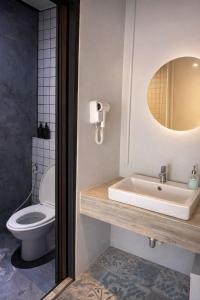 a bathroom with a toilet and a sink and a mirror at Free Way Kata Beach Hostel in Kata Beach
