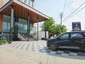 a black car parked in front of a building at Hotel Sai Paradise in Lucknow