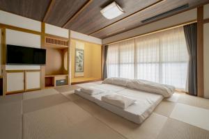 a bedroom with a bed and a flat screen tv at Premier Hotel -CABIN- Obihiro in Obihiro