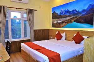 a bedroom with a bed with a large painting on the wall at Hotel Peaceland Lumbini in Rummindei +102 photos
