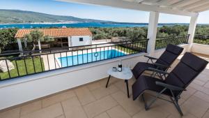 a balcony with a view of a swimming pool at Villa Estate 2 by Villas Guide in Kornić