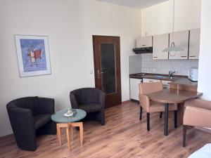 a living room with a table and chairs and a kitchen at Pension Appartementhaus Hus Möhlenbarg in Cuxhaven +38 photos