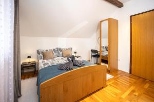 a bedroom with a bed with a wooden bed frame at Vacation house Terra in Petrovina +59 photos