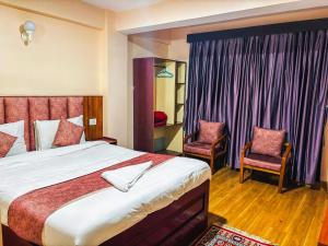 a bedroom with a large bed and two chairs at Rare Himalayas Mansarovar in Darjeeling +25 photos