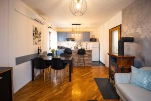 a living room with a table and chairs and a kitchen at Vacation house Terra in Petrovina