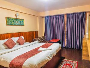 a hotel room with a bed and a window at Rare Himalayas Mansarovar in Darjeeling