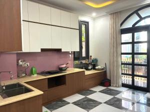 a kitchen with white cabinets and a checkered floor at Canisa Villas in Phú Quốc