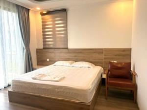 a bedroom with a bed and a chair at Canisa Villas in Phú Quốc