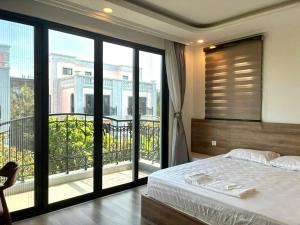 a bedroom with a bed and a large window at Canisa Villas in Phú Quốc