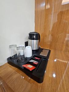 a black tray with a pot and glasses on a table at Hotel Sai Paradise in Lucknow