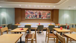 a restaurant with tables and chairs and a painting on the wall at Vitash Inn in Tirupati