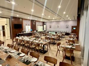 a large dining room with tables and chairs at Sur Grand Hotel in Sur