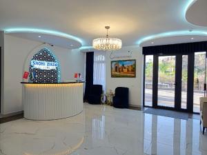 a lobby with a reception desk and a chandelier at SHOHI ZINDA Hotel in Samarkand