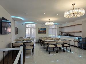 a dining room with tables and chairs and chandeliers at SHOHI ZINDA Hotel in Samarkand