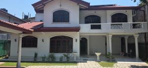 a large white house with a red roof at Silver Spring Villa in Siyambalape