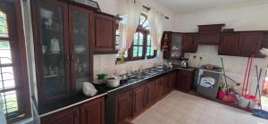 a kitchen with wooden cabinets and a sink at Silver Spring Villa in Siyambalape
