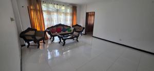 a living room with chairs and a table and a mirror at Silver Spring Villa in Siyambalape +5 photos