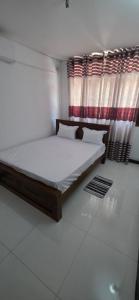 a bedroom with a bed and a window with curtains at Silver Spring Villa in Siyambalape