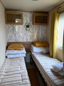 two beds in the back of a trailer at Buckley's Retreat - 3 Bedroom Family Caravan overlooking fishing lakes at Golden Palm Resort in Chapel Saint Leonards +7 photos