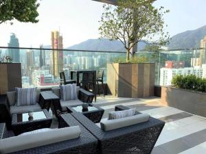 a rooftop patio with chairs and tables on a building at Ehotel in Hong Kong