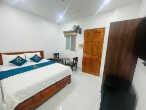a bedroom with a bed and a table and chairs at Anh Duy Hotel in Nhơn Trạch +12 photos
