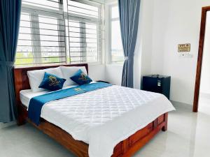 a bedroom with a bed with blue and white pillows at Anh Duy Hotel in Nhơn Trạch