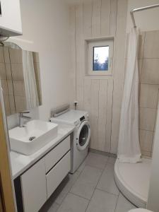 a white bathroom with a washing machine and a sink at Brīvdienu māja in Jelgava +27 photos