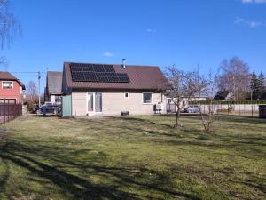 a house with solar panels on top of a yard at Brīvdienu māja in Jelgava
