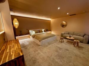 a bedroom with a bed and a couch and a table at ExSPArience Private Spa Suite in Poitiers