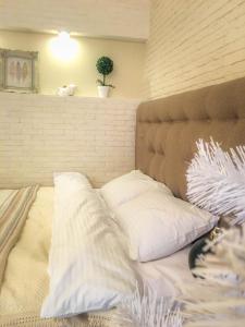 a bed with white pillows on it in a room at Studio Luxe on Victory Street in the city center in Vinnytsya