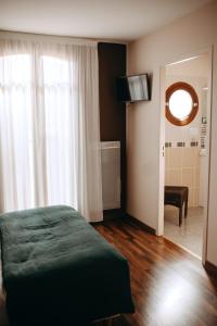 a bedroom with a bed and a window and a bathroom at Logis - Hotel Restaurant du Parc in Cransac