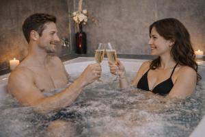 a man and woman drinking champagne in a bathtub at Konsum Gästehaus Quisisana - Oberhof in Oberhof