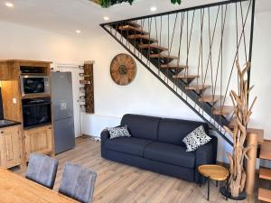 a living room with a blue couch and a staircase at L Amy-Côtier in Saint-Pierre-dʼOléron