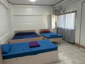 a room with two beds and a window at En Pensionne, Lodging in Iloilo City