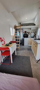 ein Wohnzimmer mit einem Tisch und einer Küche in der Unterkunft Tiny bleu in Naujac-sur-Mer