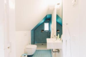 a bathroom with a toilet and a sink at Kapitänshaus Wieck in Wieck +25 photos