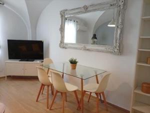 a dining room with a table and chairs and a mirror at Apartamentos La Machacona Plaza Mayor recién reformados in Cáceres +41 photos