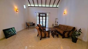 a living room with a couch and a table at Villa Mango Serenity in Hikkaduwa