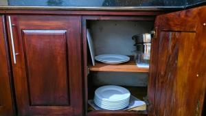 a cabinet with plates and bowls in a kitchen at Villa Mango Serenity in Hikkaduwa +47 photos