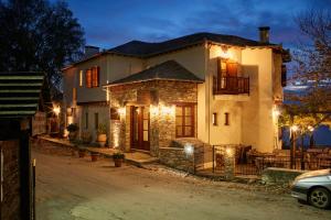 Una gran casa blanca con luces en una calle en Hotel Dryades and Spa, en Agios Lavredios