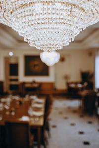 a large chandelier in a room with tables and chairs at Logis - Hotel Restaurant du Parc in Cransac +85 photos