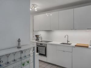 a white kitchen with white cabinets and a sink at Objekt-Nr 86 - Priwall - Wiekstraße in Priwall +2 photos