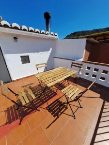 a deck with a table and chairs on a roof at Casa Trilles in Azuébar