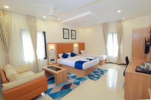 a hotel room with a bed and a living room at Vitash Inn in Tirupati