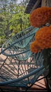 a green metal bench with orange flowers on it at Glamping in Malinalco in Malinalco +1 photo