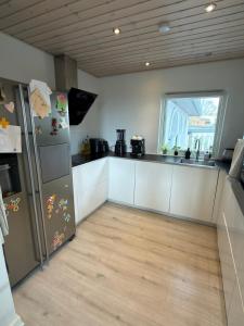 a kitchen with white cabinets and a refrigerator at Sweet Home in Aarhus +10 photos