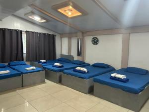 a room with four beds with blue pillows at En Pensionne, Lodging in Iloilo City
